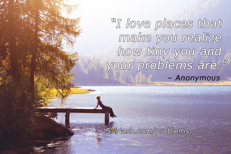 Inspirational quote about problems - woman sat next to lake: "I love places that make you realize how tiny you and your problems are"